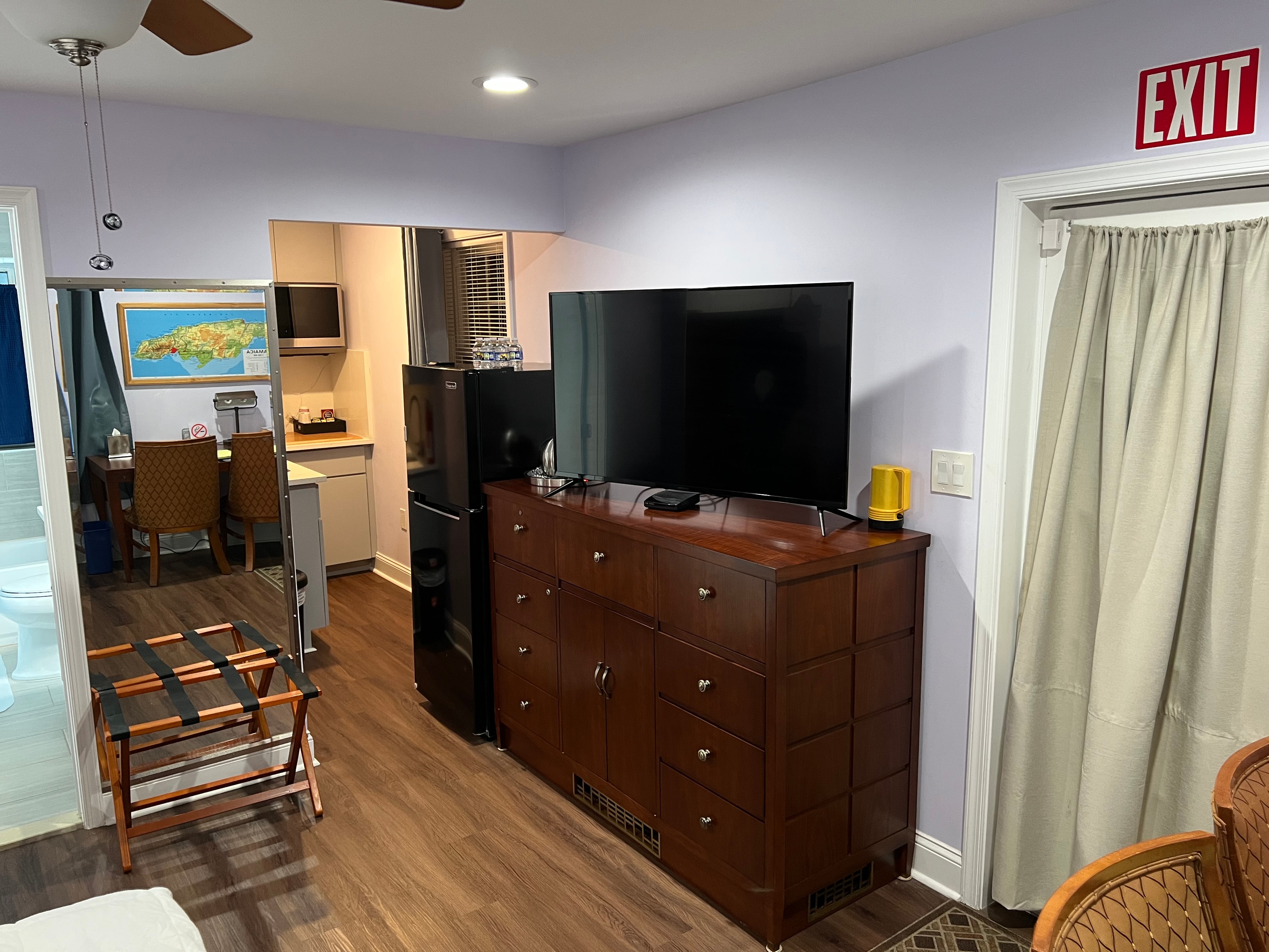 Guest room with refrigerator, smart TV and dresser