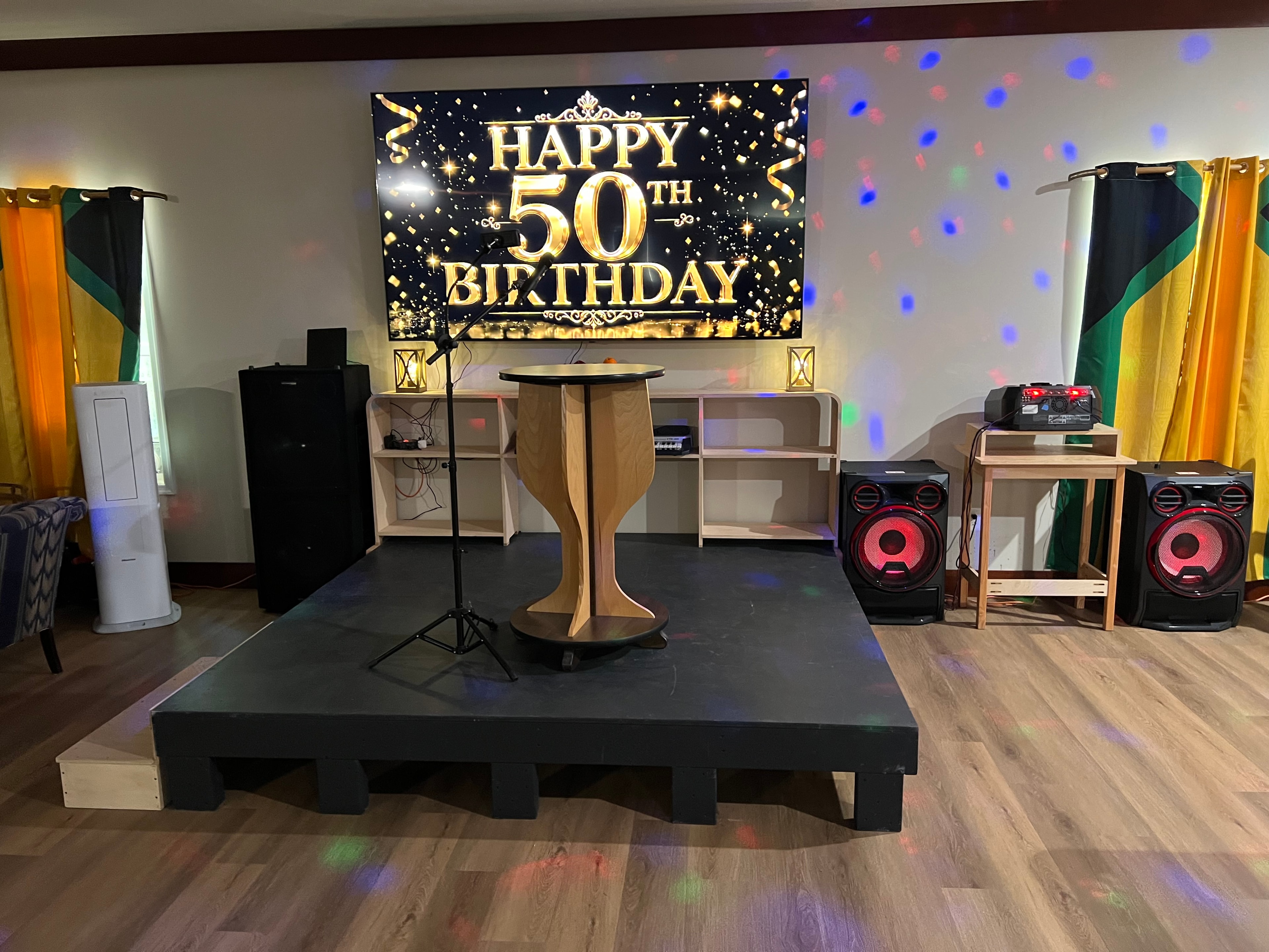 Entertainment space set up for a 50th birthday celebration with stage and speakers