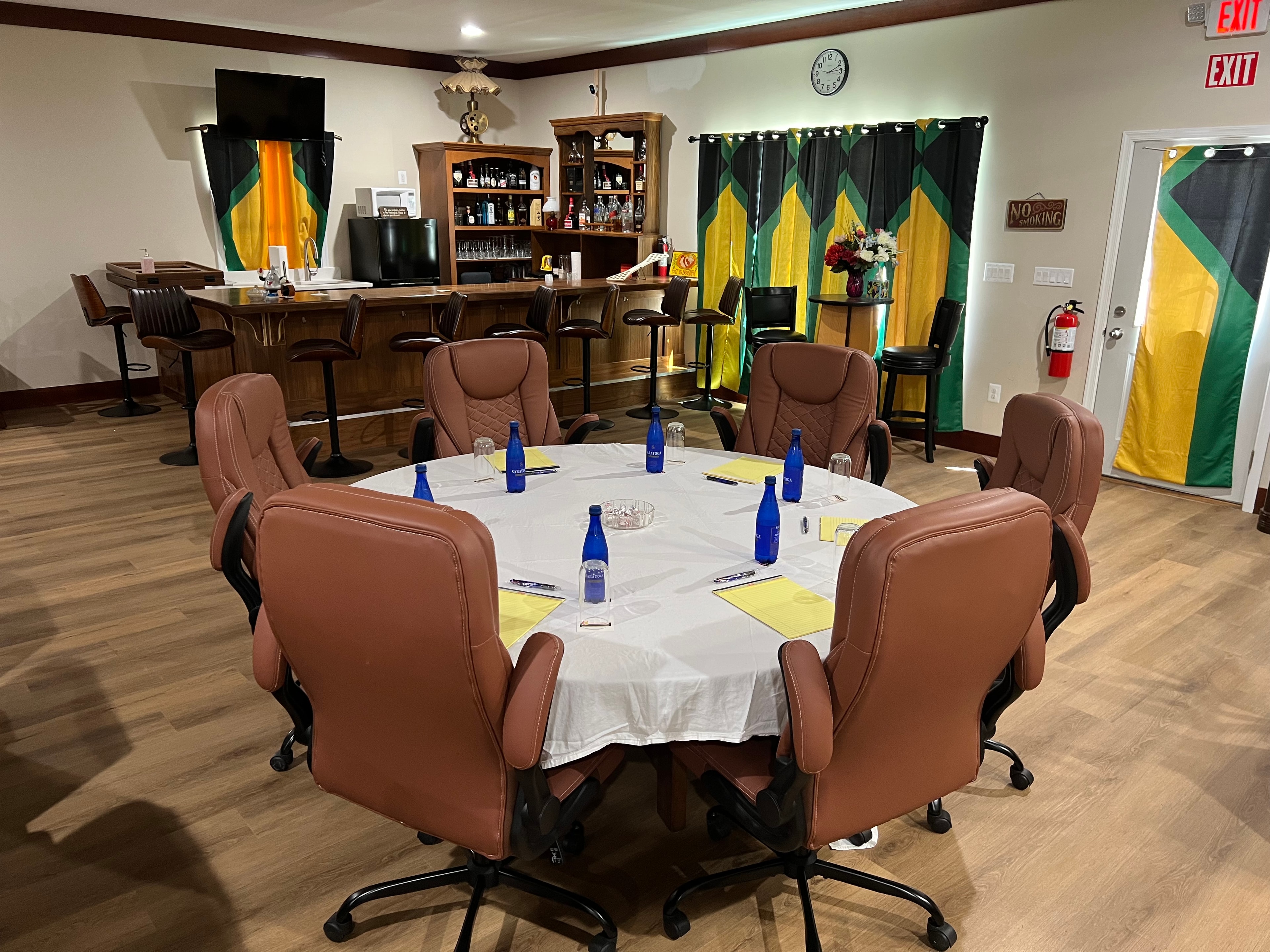 Round table meeting setup with Jamaican-themed decor and bar