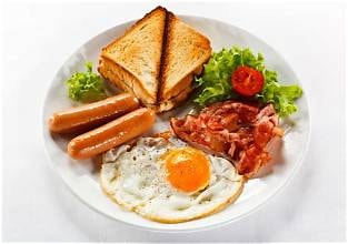 Carib Comfort breakfast — fried egg, sausage, bacon and toast