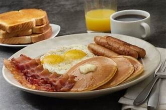Carib Comfort breakfast — eggs, bacon, sausage and pancakes